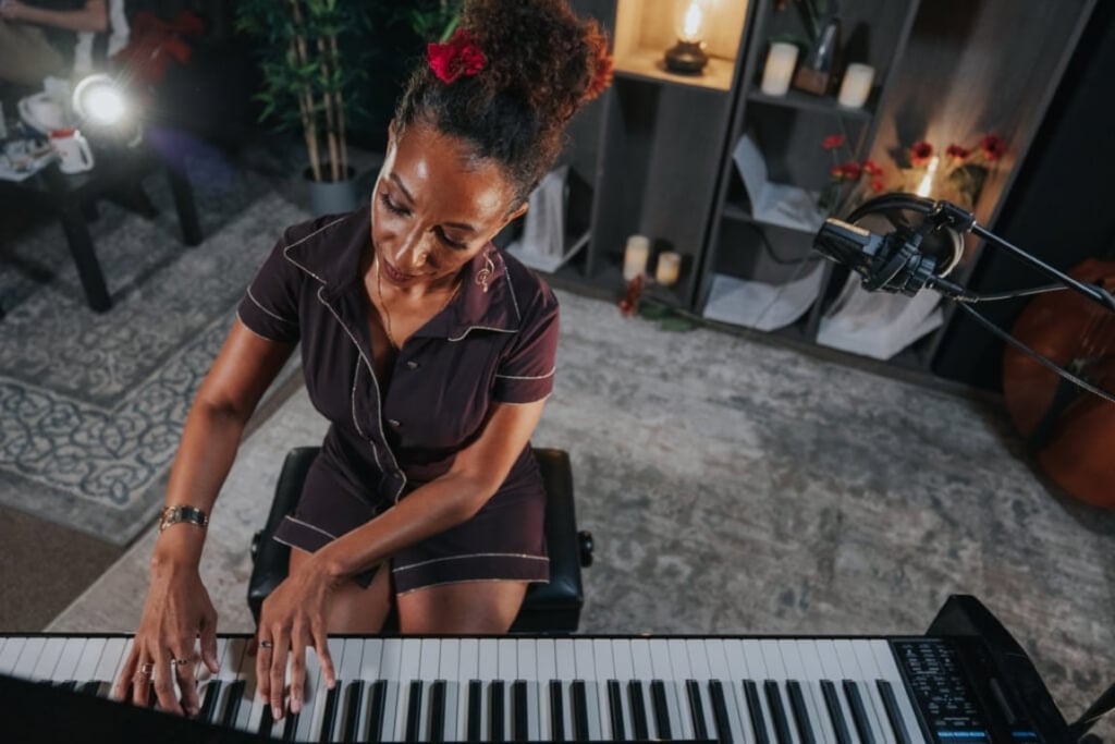 In front and above view of woman playing piano with rose in hair.